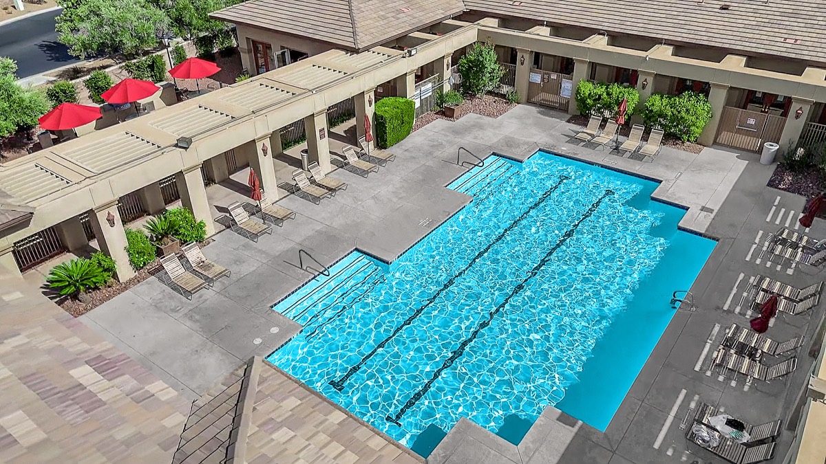 Southern Terrace's lap-style community pool, lined with lounge chairs and umbrellas